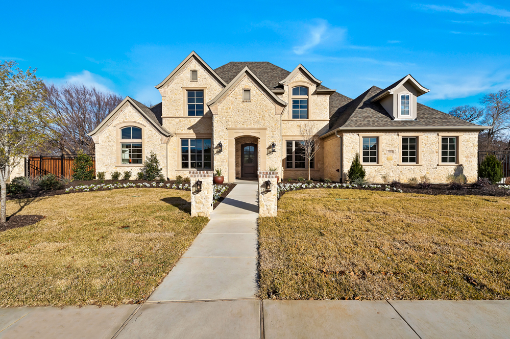 View of a custom two-story luxury home from the sidewalk.