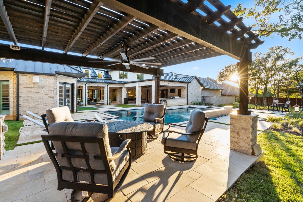 View of pergola with outdoor fan and fire pit, looking into a Keller estate built by Garabedian Properties.