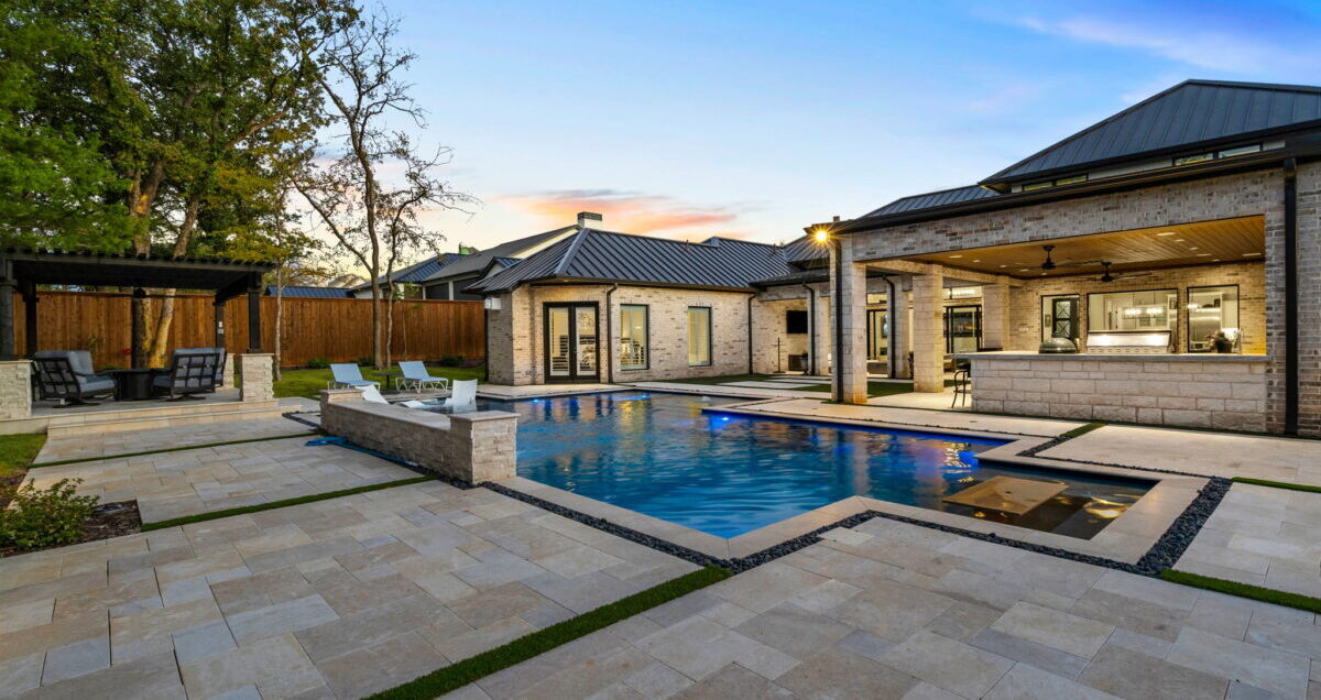Gorgeous custom luxury poolscape with custom home in the background.