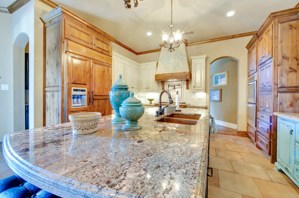 Custom luxury estate kitchen with granite counters nad pot filler mounted above the stove.