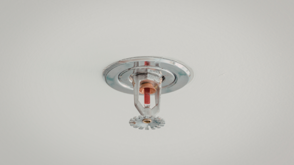 Ceiling-mounted residential fire sprinkler head installed in conditioned space to reduce risk during freeze conditions.