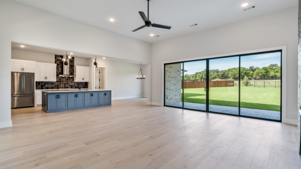 Empty great room in a custom home with large sliding glass doors, illustrating interior spaces to monitor when a home is vacant during cold weather.