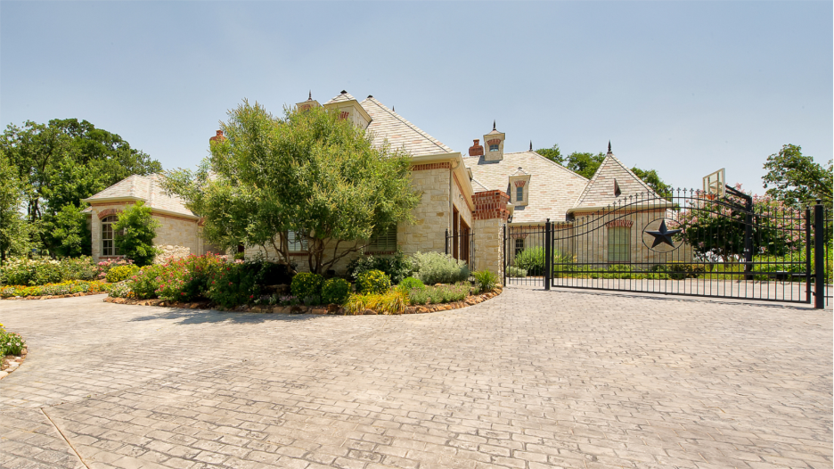 Custom home with rod iron motorized driveway gate