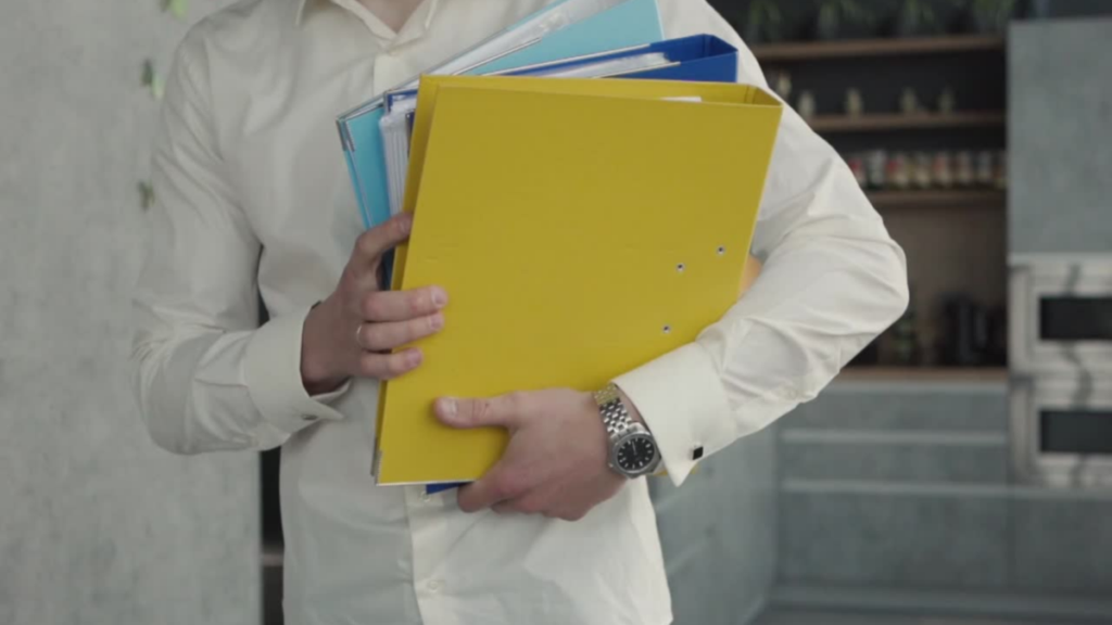 Person holding three binders of design inspiration for home design meeting.