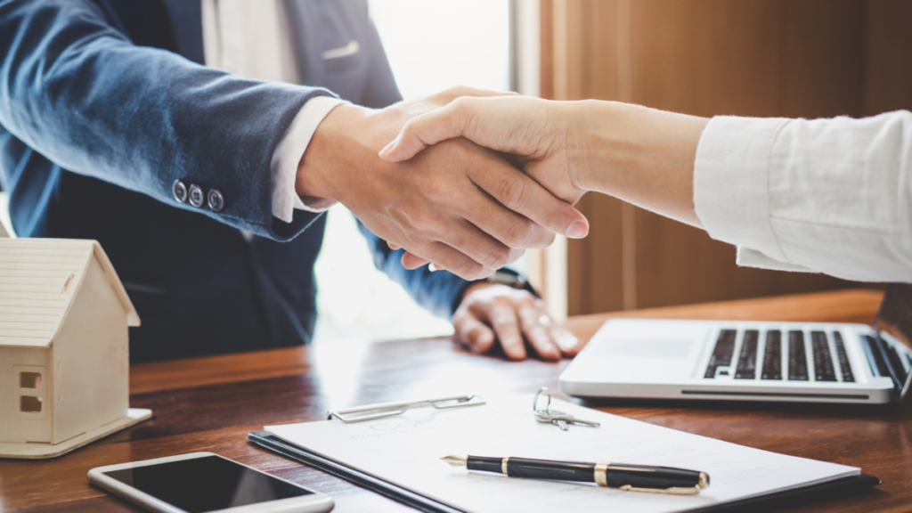 Two people shaking hands indicating a contract agreement to purchase a custom home.