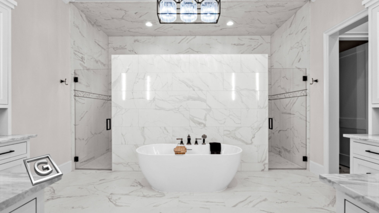 Garabedian Properties premier residential builder North Texas — floor-to-ceiling white marble primary bathroom with continuous stone veining across walls, ceiling, and floors, freestanding soaking tub centered between frameless glass shower enclosures, and a statement crystal chandelier overhead